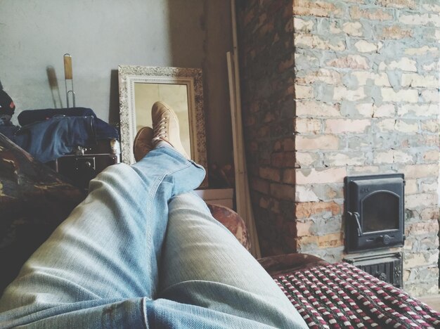 Photo low section of man relaxing on sofa at home