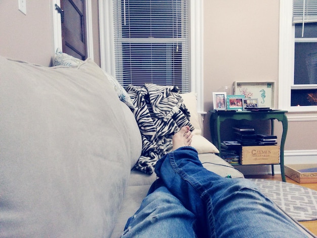 Photo low section of man relaxing on sofa
