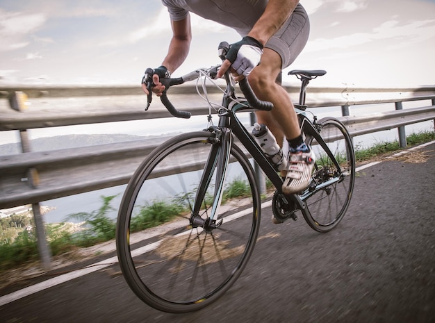 空の向こうの道路で自転車に乗っている男性の低い部分