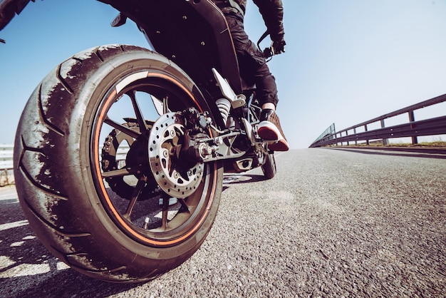 Low section of man riding bicycle on road