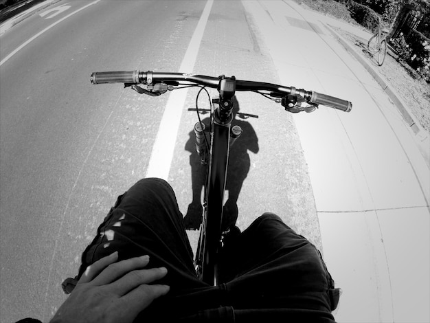 Photo low section of man riding bicycle on road