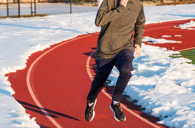 Photo low section of man running on sports track during winter