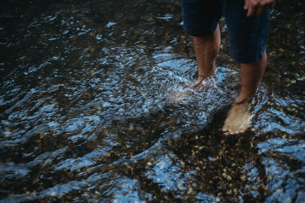 Photo low section of man sanding in river