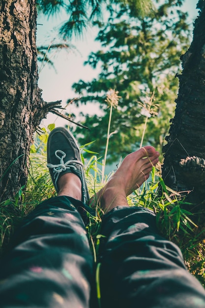 Foto sezione bassa di un uomo seduto su un campo erboso