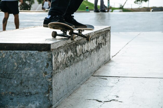 Foto sezione bassa dell'uomo che fa skateboard sul sentiero