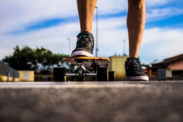 Foto sezione bassa di skateboarding maschile