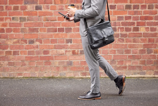 Photo low section of man standing against brick wall