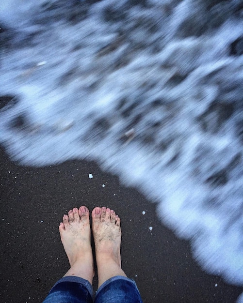 Foto sezione bassa di un uomo in piedi sulla spiaggia