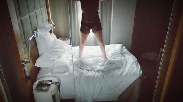 Photo low section of man standing on bed