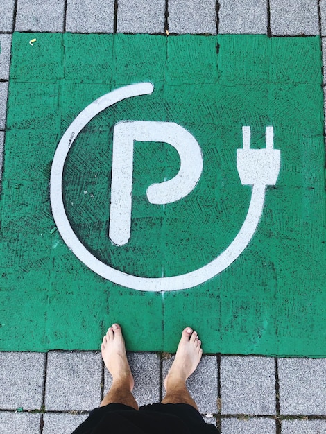 街の駐車場の看板に立っている男性の低いセクション