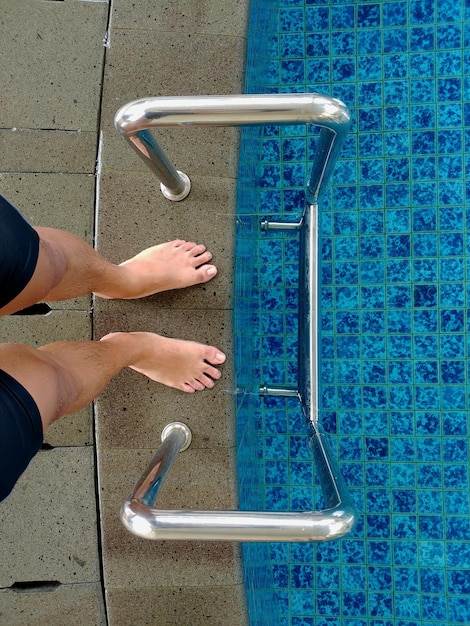 Photo low section of man standing by poolside