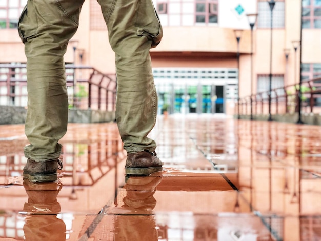 low section of man standing by water