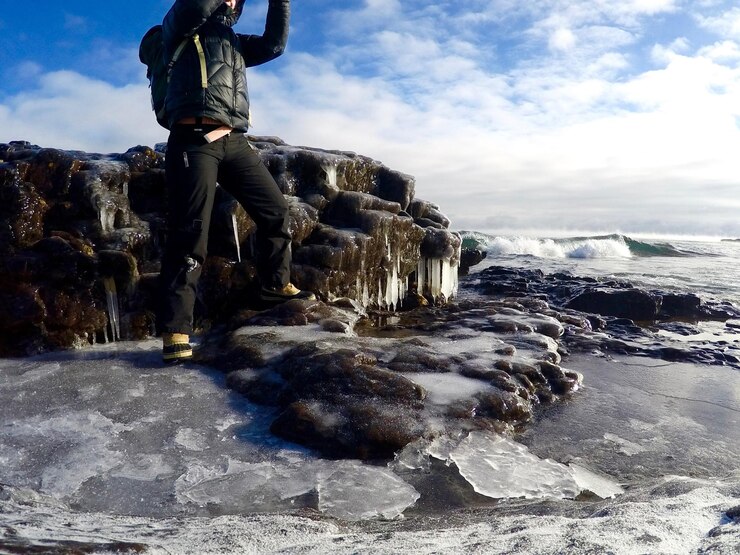 Photo low section of man standing on frozen beach against sky