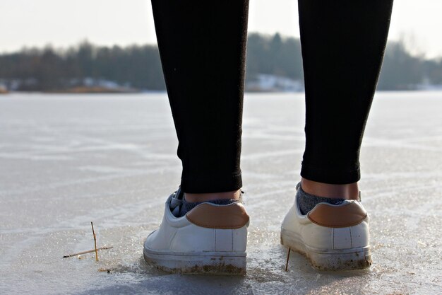 Photo low section of man standing on frozen lake