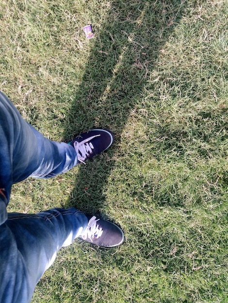 Foto sezione bassa di un uomo in piedi su un campo erboso