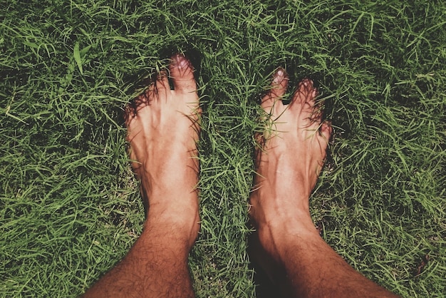 Photo low section of man standing on grassy field