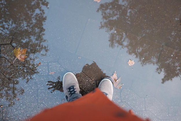 Low section of man standing on puddle