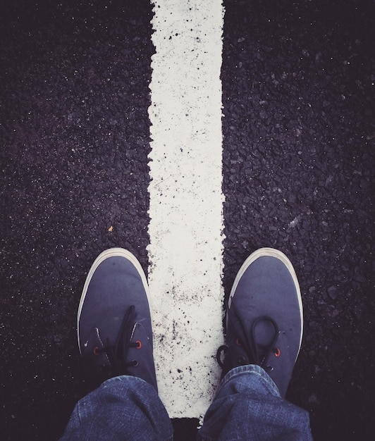 low section of man standing on road