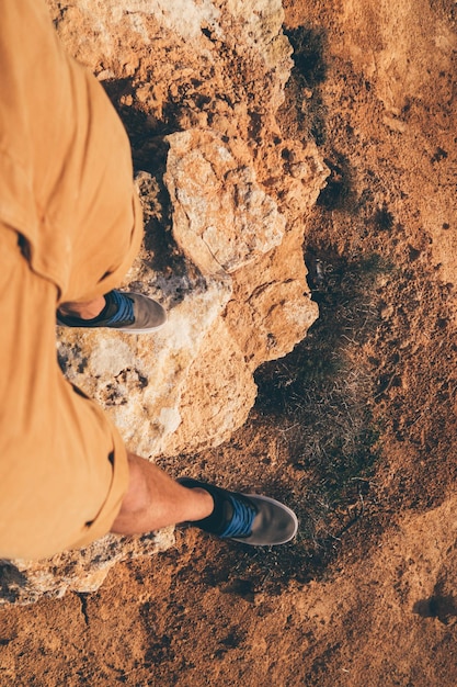 Foto sezione bassa di un uomo in piedi su una roccia