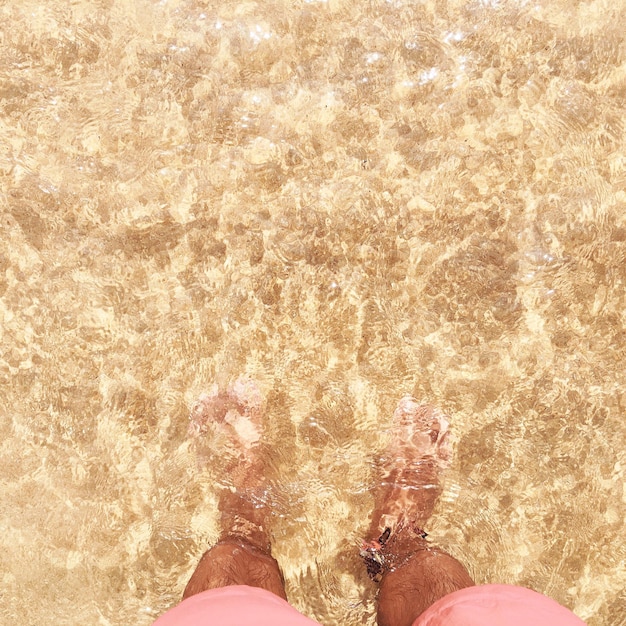 Foto sezione bassa di un uomo in piedi in mare