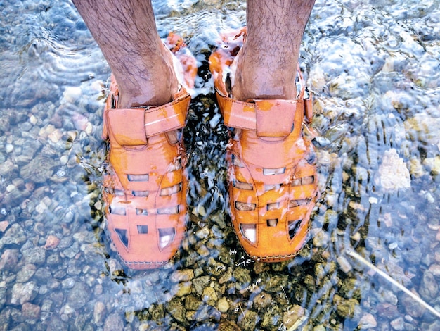 Photo low section of man standing in sea