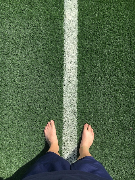 Foto sezione bassa di un uomo in piedi sul campo da calcio