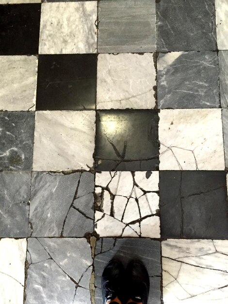 Photo low section of man standing on tiled floor