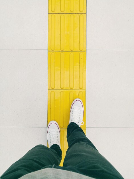 Photo low section of man standing on tiled floor