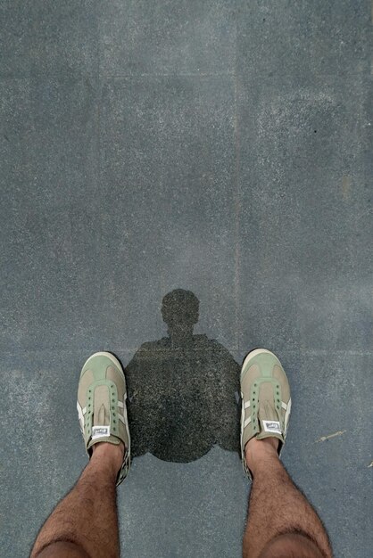 Photo low section of man standing on wet road