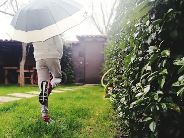 Photo low section of man standing with umbrella on yard