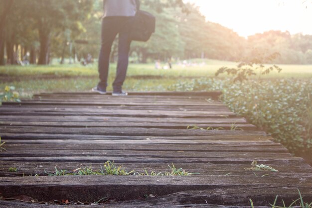 Photo low section of man standing on wood at park