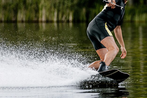 Low section of man surfing in lake