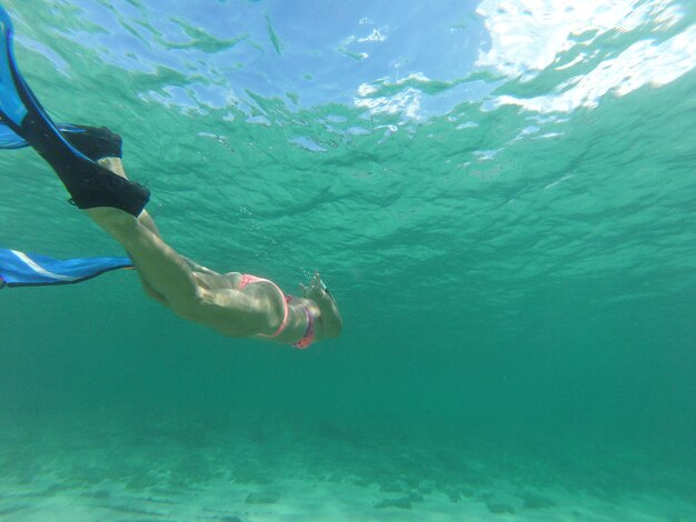 Low section of man swimming in sea