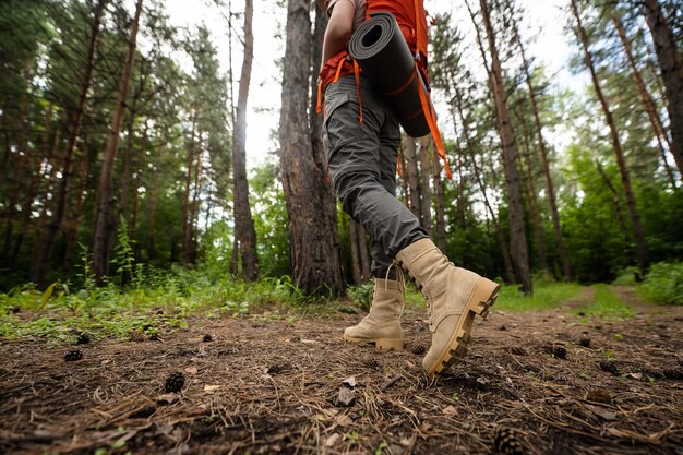 Low section of man on tree trunk in forest