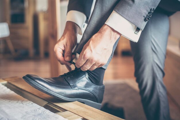 Low section of man tying shoes