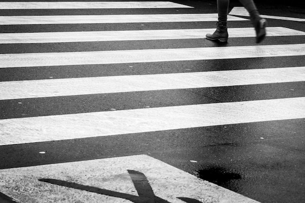 Foto sezione bassa di un uomo che cammina sul passaggio pedonale