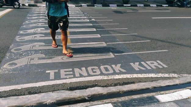 Photo low section of man walking on road