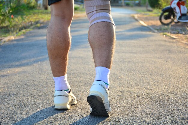 Photo low section of man walking on road