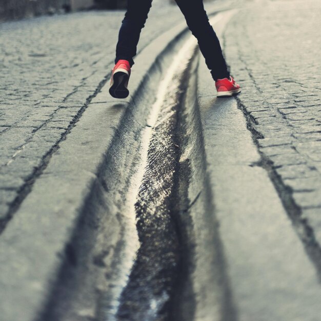 Photo low section of man walking on road