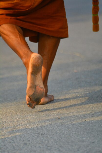 Low section of man walking on street