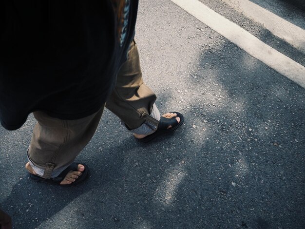 Low section of man walking on street