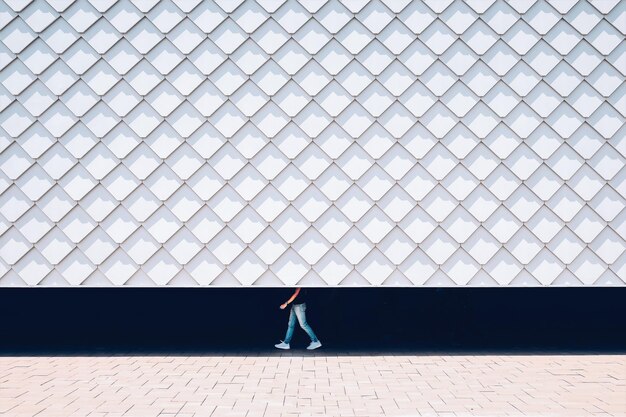 Photo low section of man walking behind wall