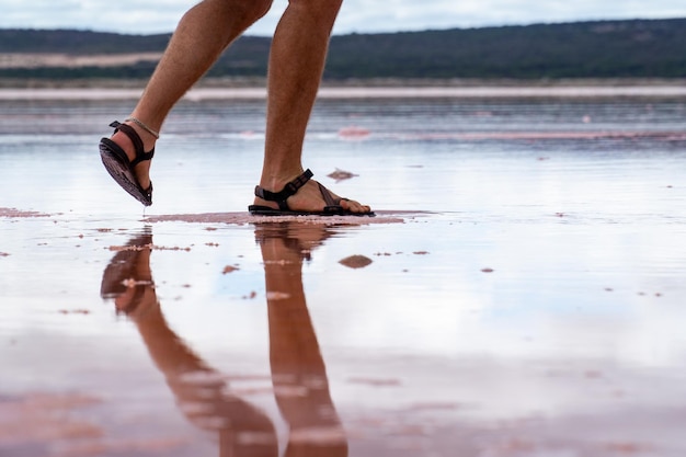 Photo low section of man walking on wet shore