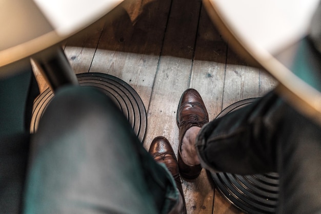 Photo low section of man wearing shoes on wooden floor