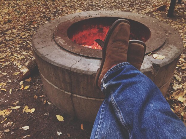 Low section of man with feet up on fire pit