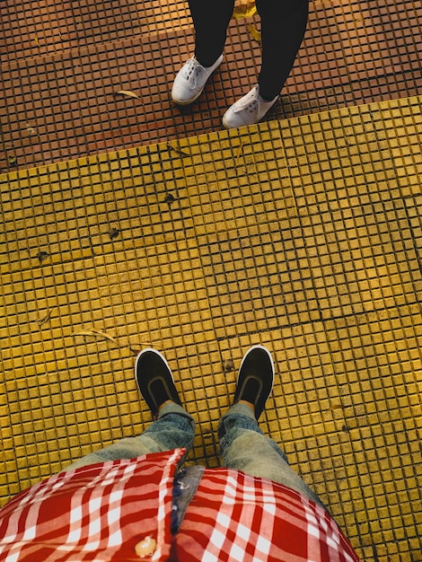 Low section of man and woman standing on tiled floor