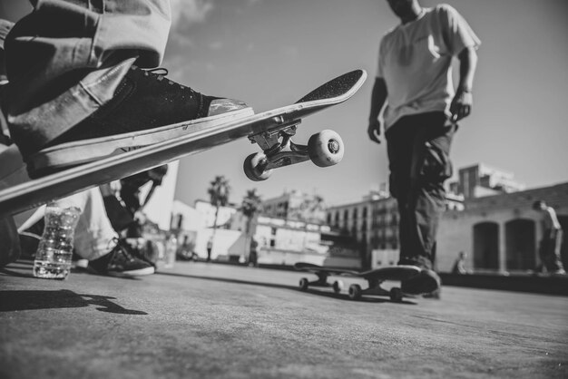 Photo low section of men skateboarding on street