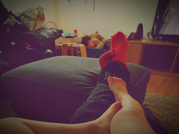 Photo low section of mother and son sitting on sofa at home