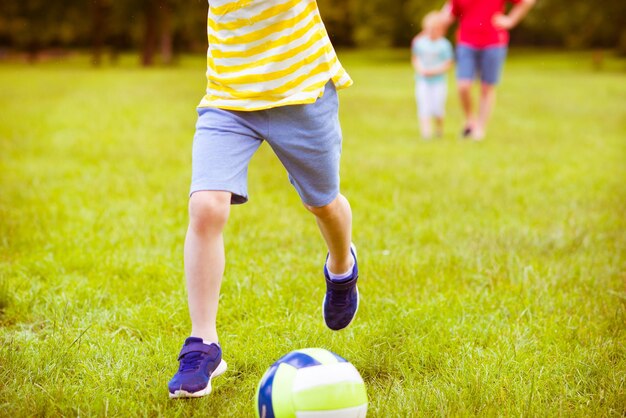 写真 フィールドでサッカーをしている少年の下部