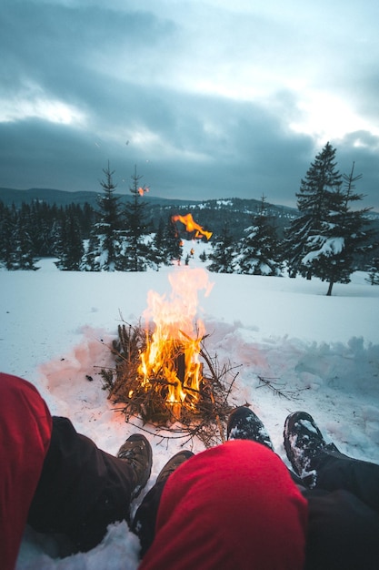 写真 雪で覆われた土地のカップルの低いセクションは火によって